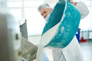Worker pouring ingredients into mixer