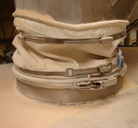 A hose-clamped connector with product leaking on the machinery